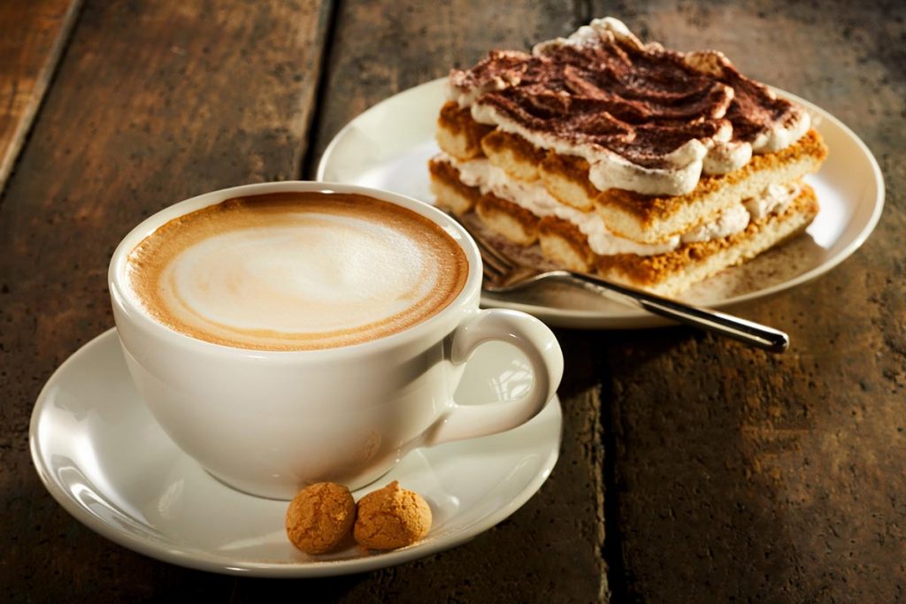 Filiżanka podwójnej kawy espresso z kawałkiem ciasta